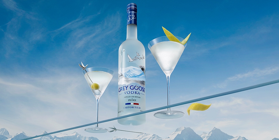 A bottle of Grey Goose vodka with a Dirty Martini Cocktail and a Dry Martini Cocktail.